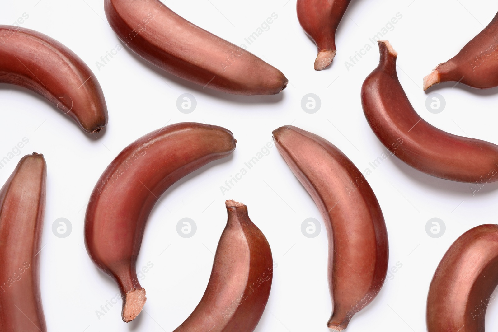 Photo of Tasty red baby bananas on white background, flat lay