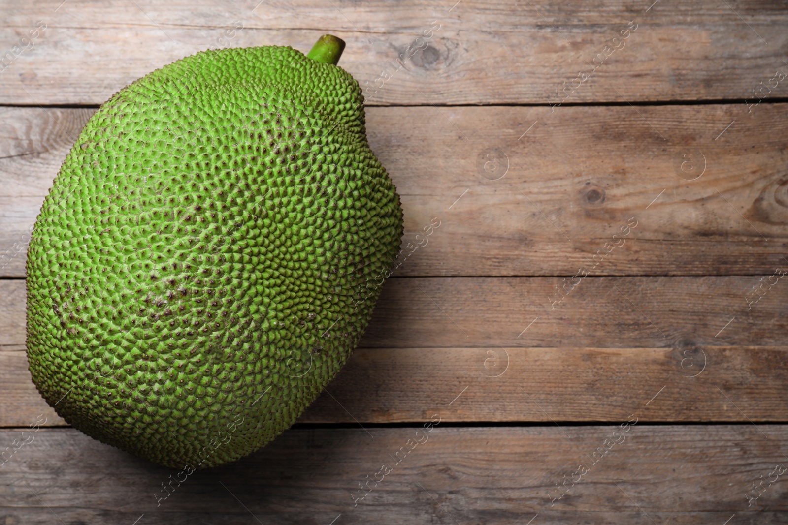 Photo of Fresh exotic jackfruit on wooden table, top view. Space for text