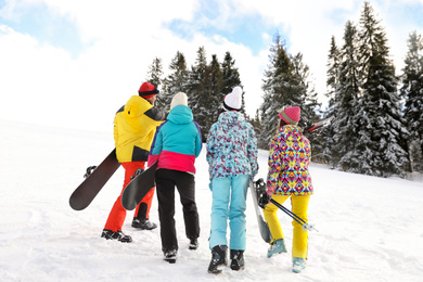 Photo of Group of friends with equipment in snowy mountains. Winter vacation