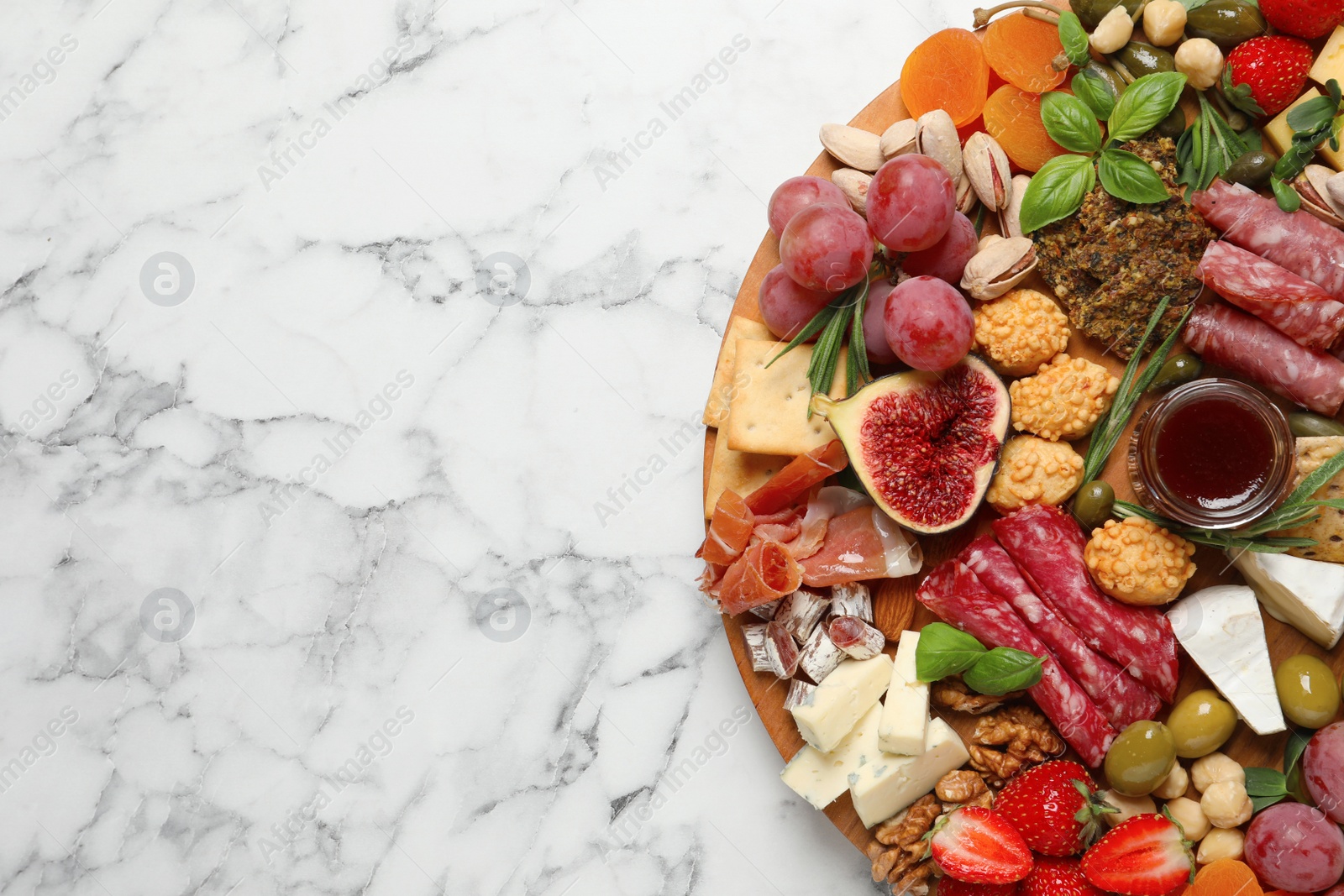 Photo of Different tasty appetizers on white marble table, top view. Space for text