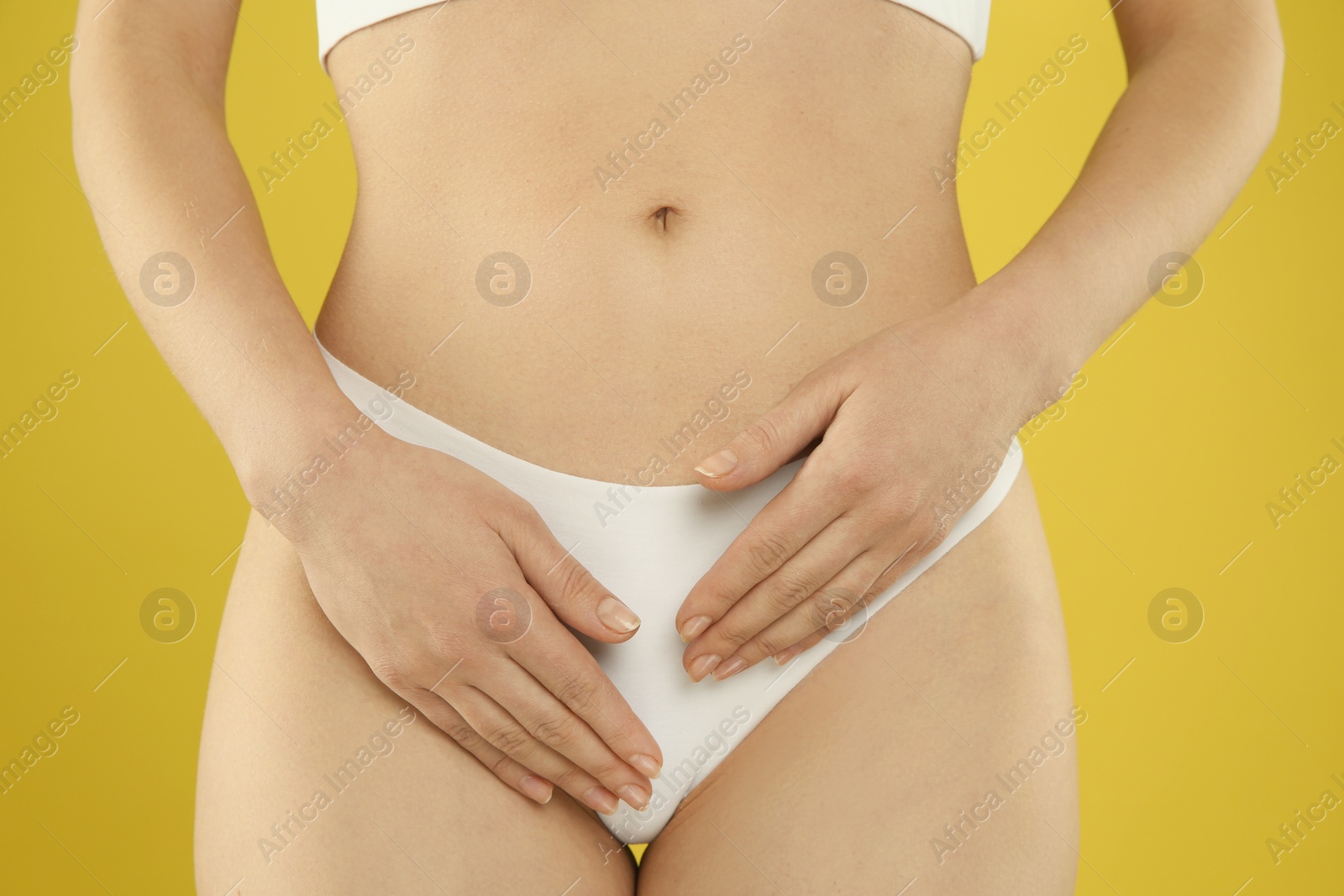 Photo of Gynecology. Woman in underwear on yellow background, closeup