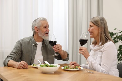 Photo of Happy senior couple having romantic dinner at home