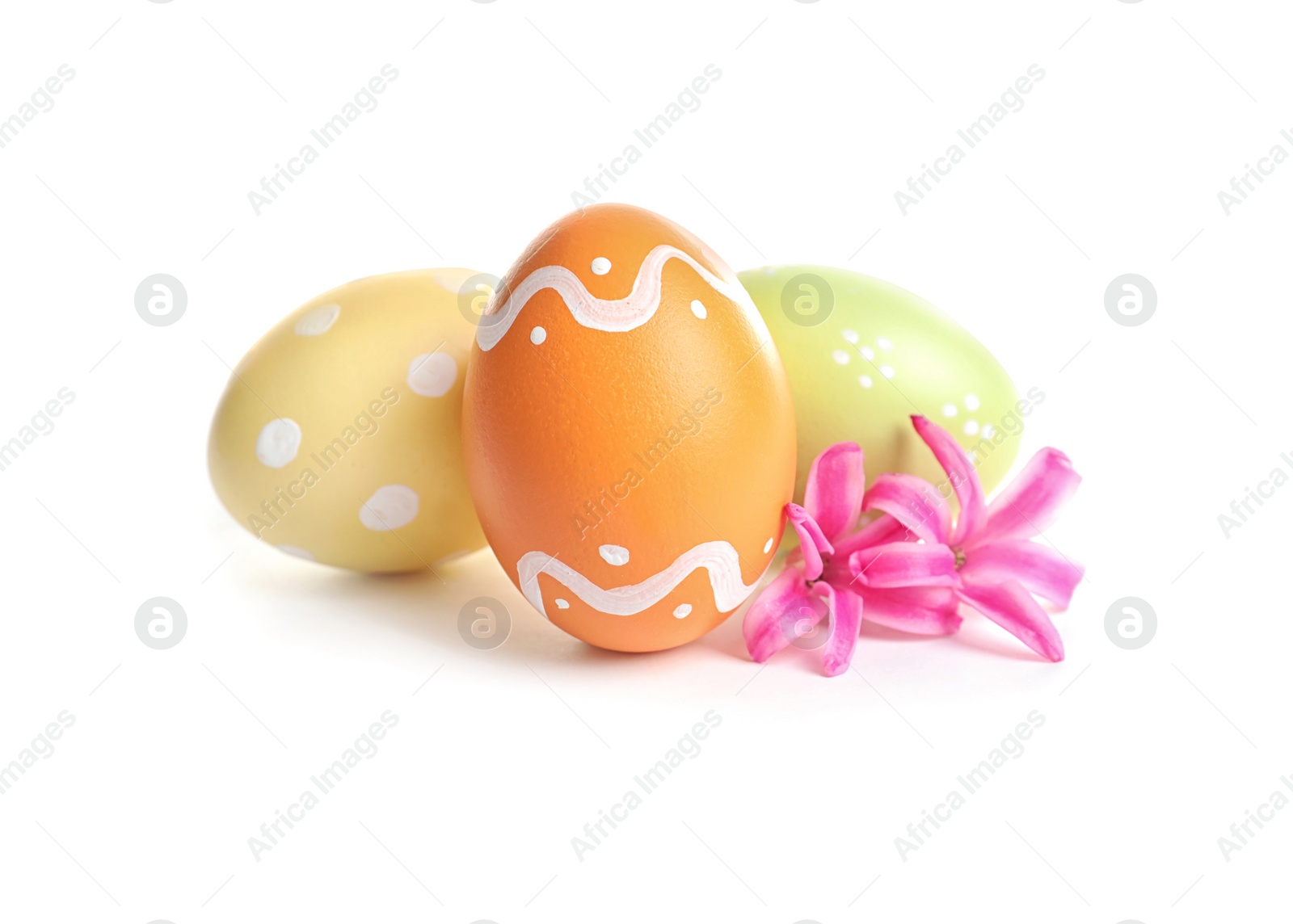 Photo of Colorful painted Easter eggs and flowers on white background