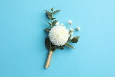 Photo of Small stylish boutonniere on light blue background, top view