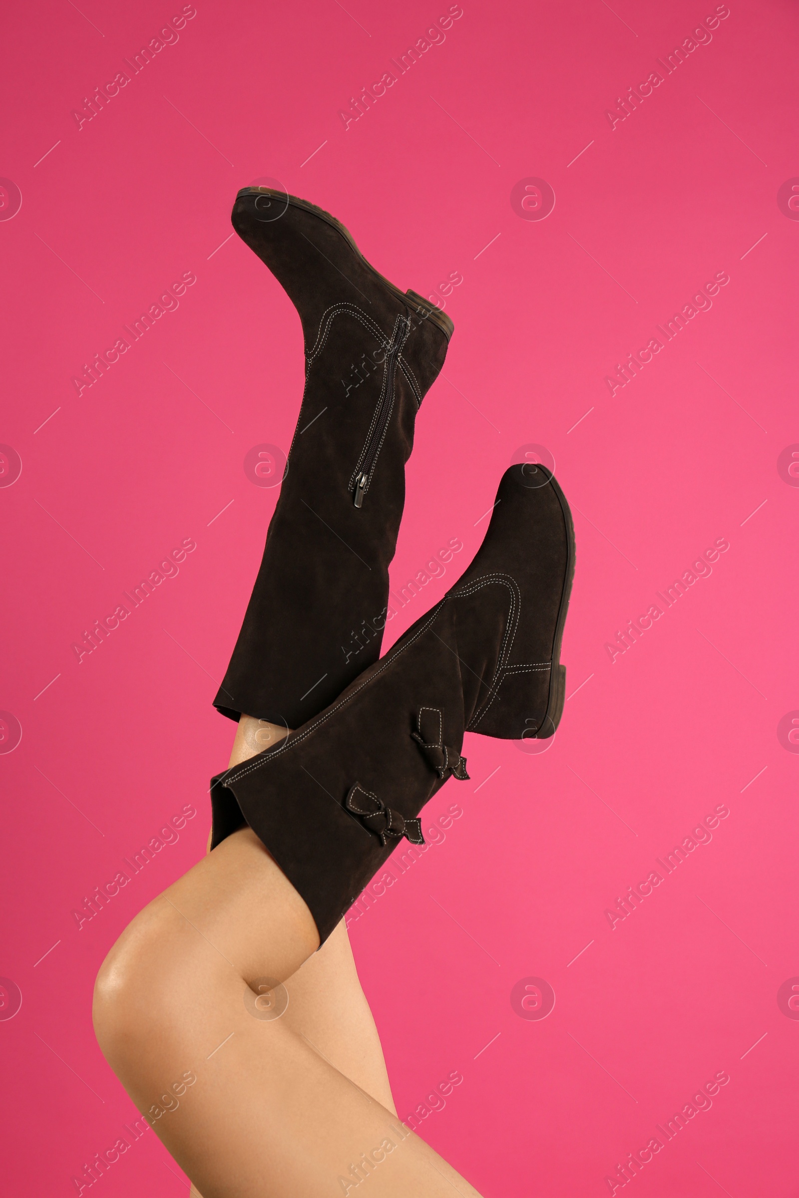 Photo of Woman wearing stylish boots on pink background, closeup