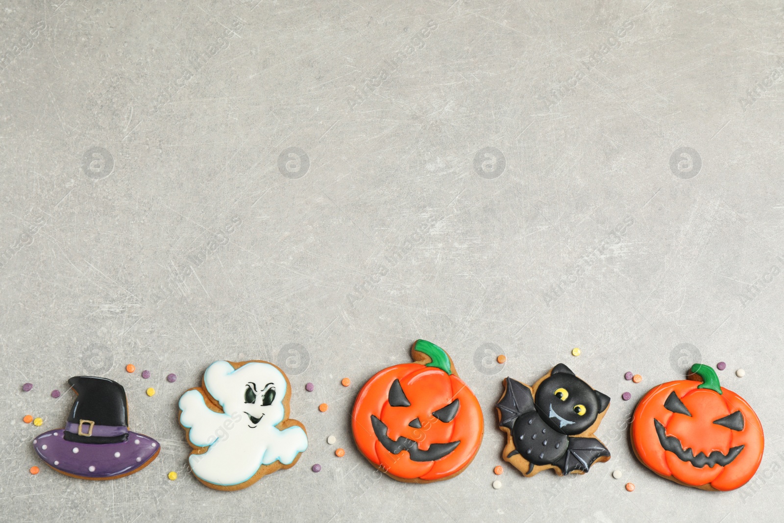 Photo of Tasty Halloween cookies on light grey table, flat lay. Space for text