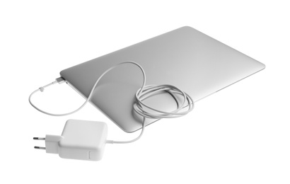 Photo of Laptop and charger on white background. Modern technology