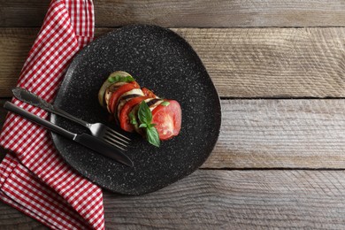 Delicious ratatouille served with basil on wooden table, top view. Space for text