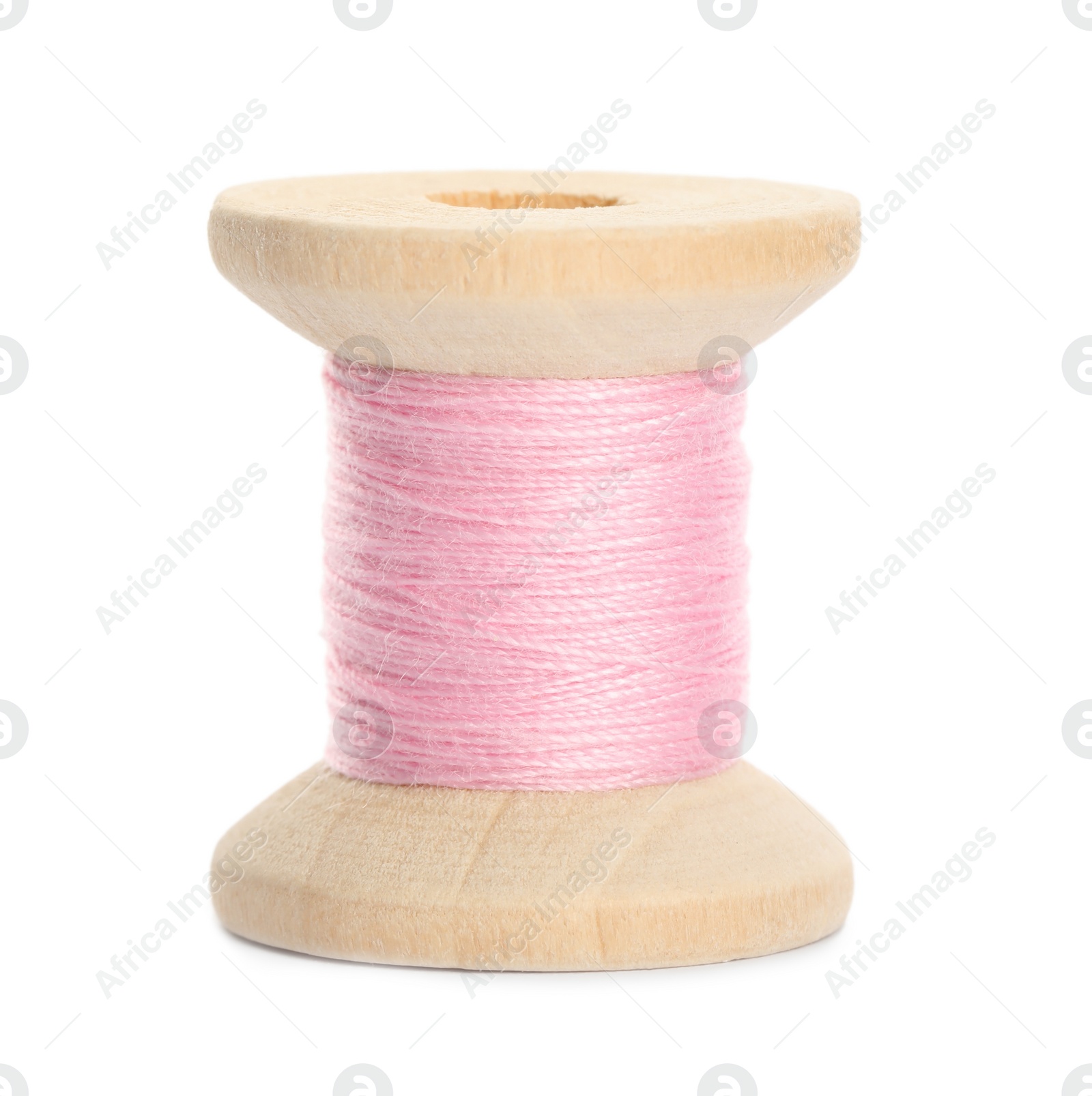 Photo of Wooden spool of pink sewing thread isolated on white