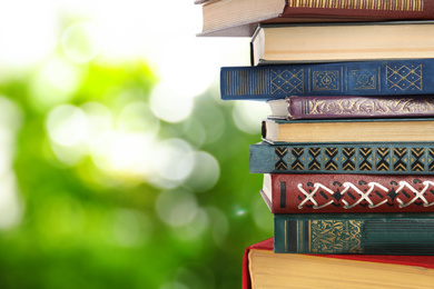 Image of Collection of different books on blurred green background, space for text