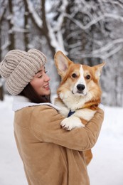 Photo of Woman with adorable Pembroke Welsh Corgi dog in snowy park
