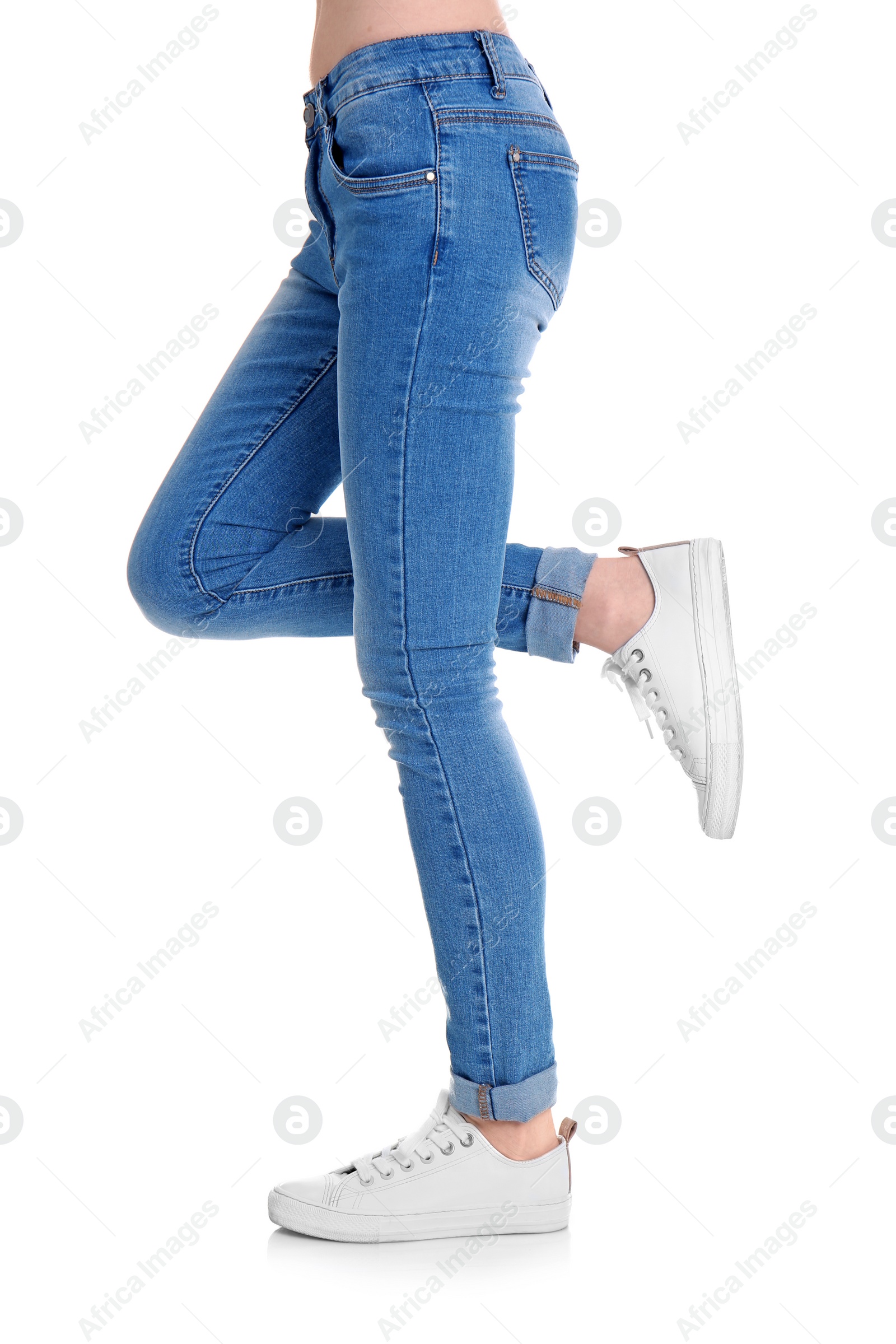 Photo of Young woman in stylish jeans on white background