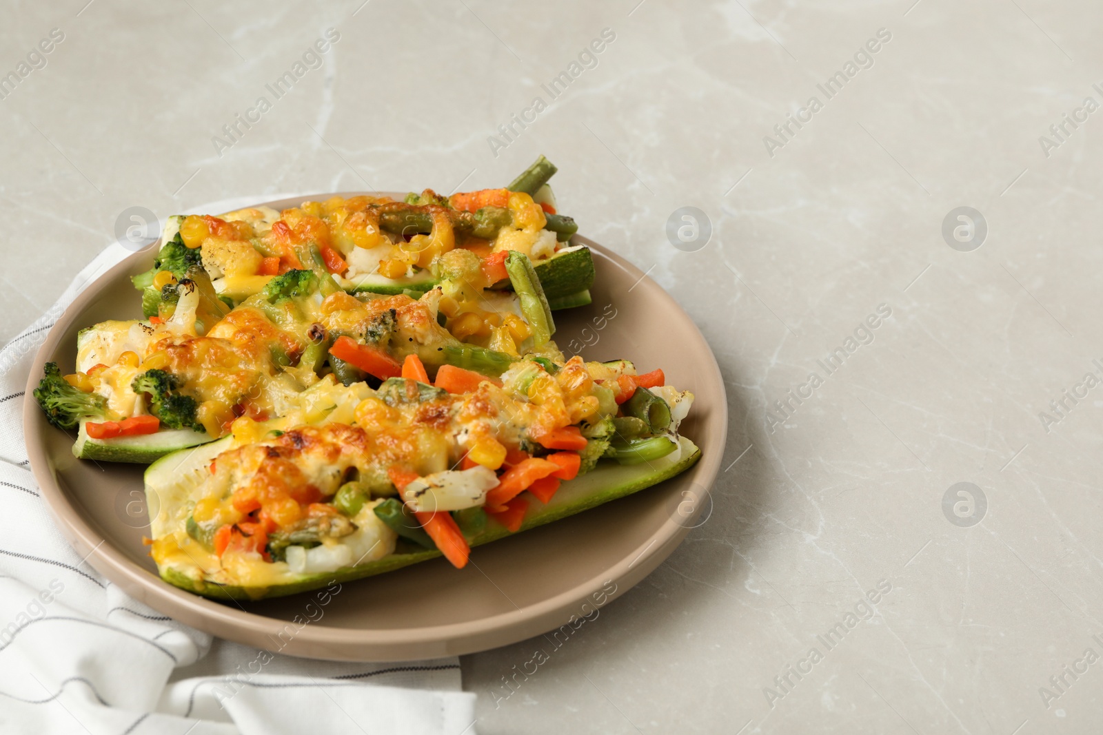 Photo of Baked stuffed zucchinis served on light grey table