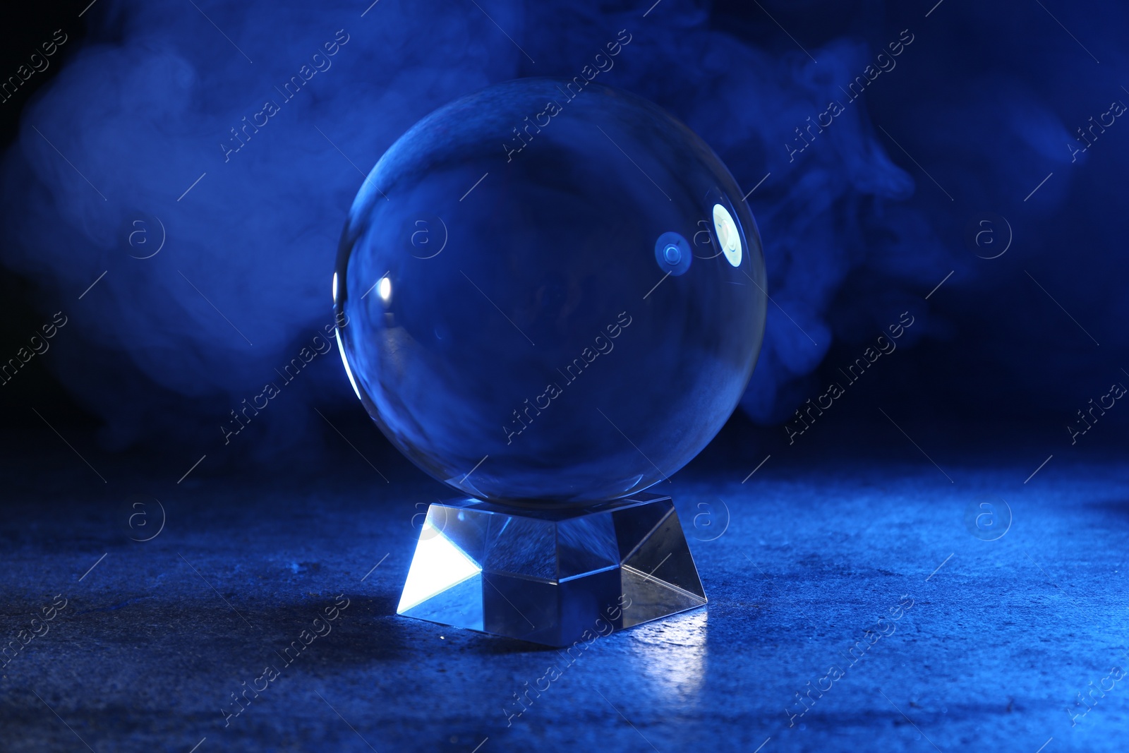 Photo of Magic crystal ball on table against dark background. Making predictions