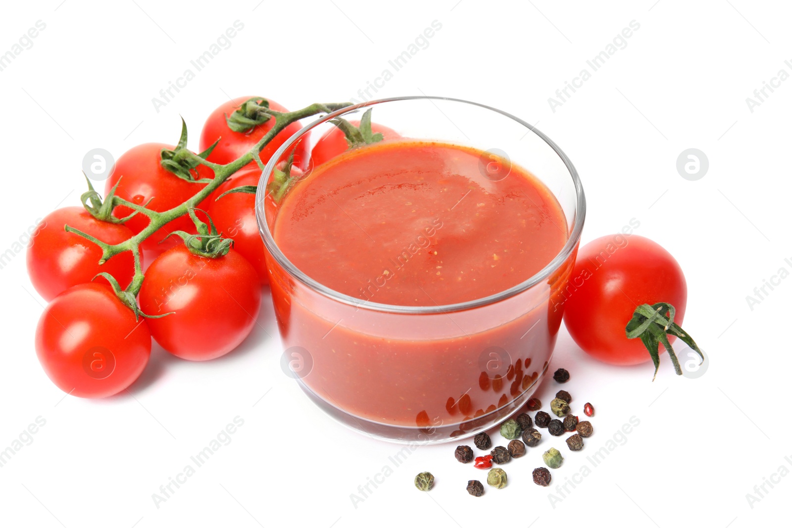 Photo of Glass of sauce, tomatoes and pepper isolated on white