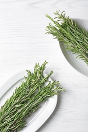 Flat lay composition with rosemary on wooden background. Aromatic herbs