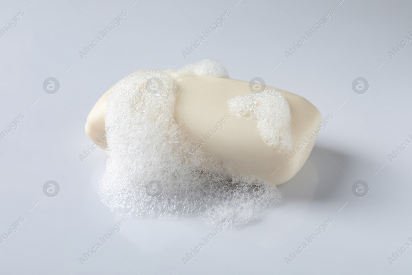 Photo of Soap with fluffy foam on white background