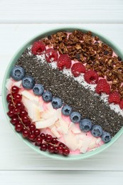 Tasty smoothie bowl with fresh berries and granola on white wooden table, top view