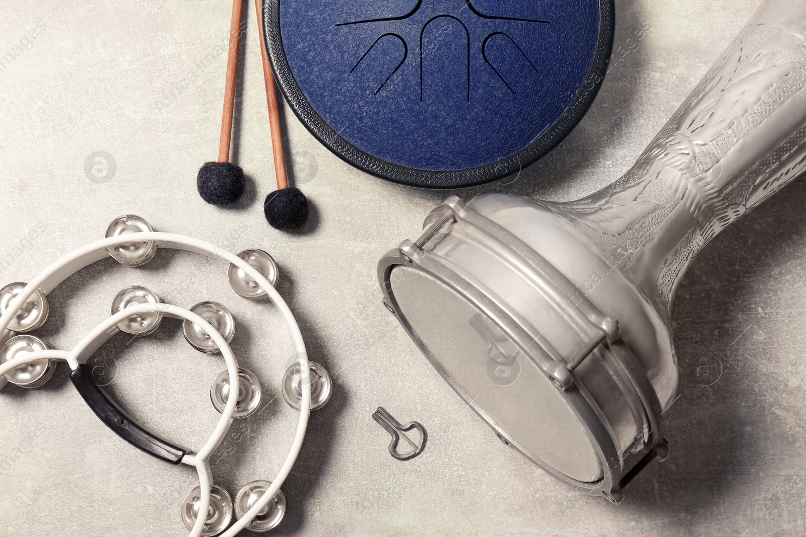 Photo of Different percussion musical instruments on light grey background, flat lay