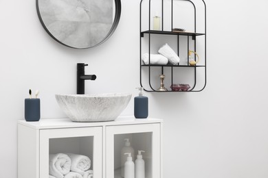 Different bath accessories, personal care products and bathroom vanity indoors