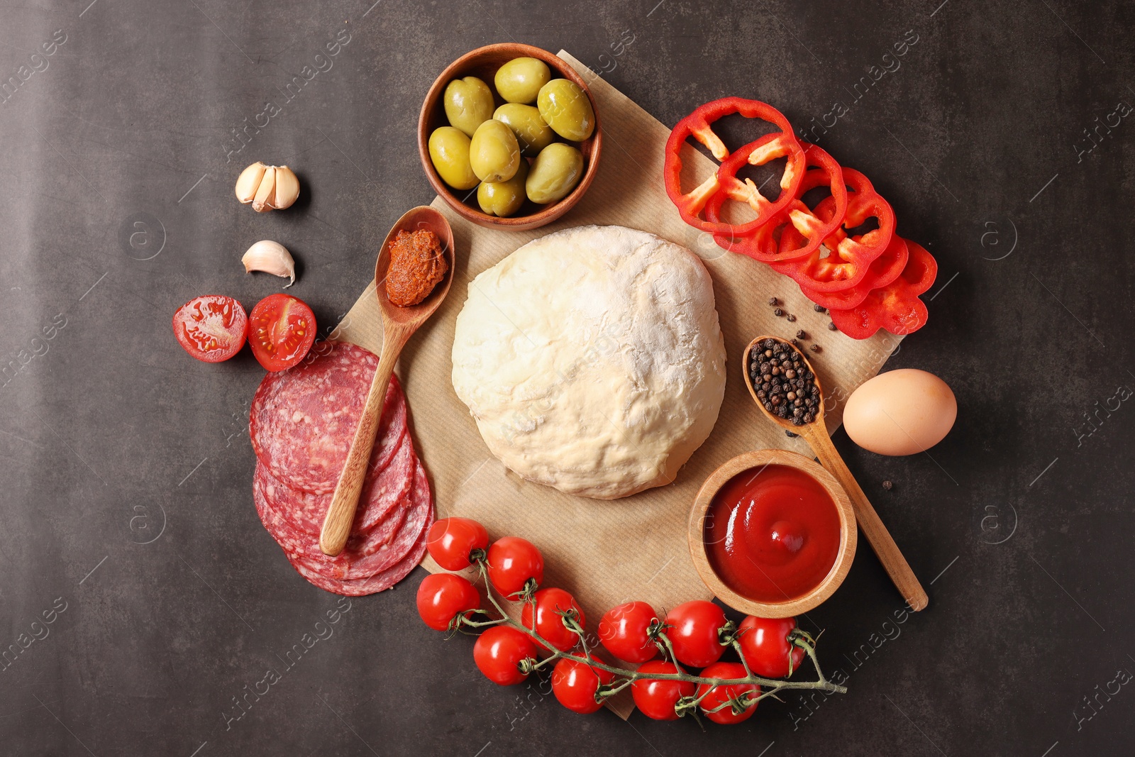 Photo of Pizza dough and products on dark table, flat lay