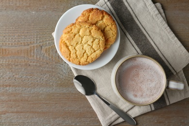 Composition with delicious hot cocoa drink and cookies on wooden background, flat lay