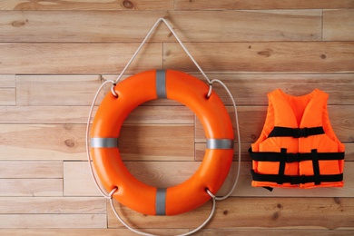 Photo of Orange life jacket and lifebuoy on  wooden background. Rescue equipment