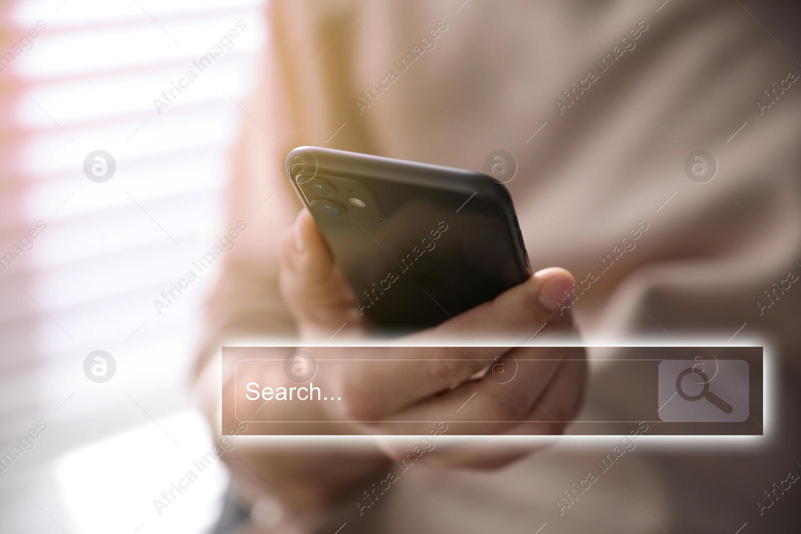 Image of Search bar of website near smartphone. Man using device indoors, closeup