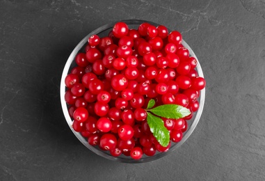 Photo of Fresh cranberry in bowl on dark grey table, top view