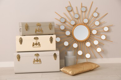 Storage trunks, cushion, vase and beautiful mirror indoors. Interior design