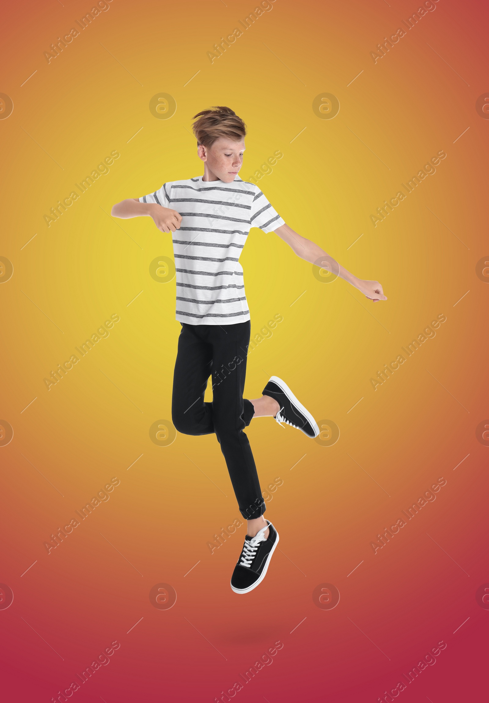 Image of Teenage boy jumping on color gradient background