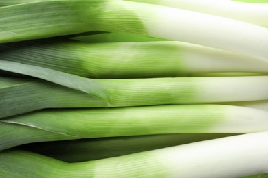 Photo of Fresh raw leeks as background, top view