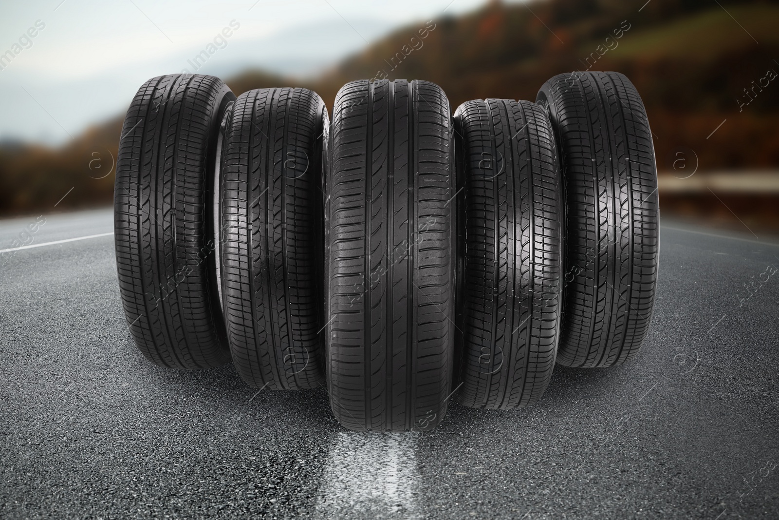 Image of Black car tires on asphalt road outdoors