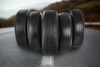 Image of Black car tires on asphalt road outdoors