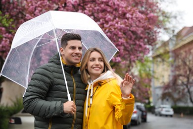 Lovely couple with umbrella walking on spring day