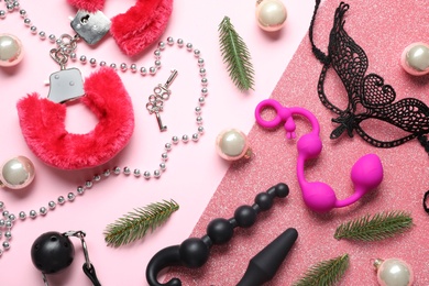 Photo of Set of different sex toys and Christmas decorations on pink background, flat lay