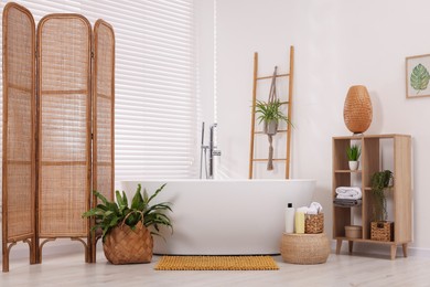 Photo of Stylish bathroom interior with soft bath mat and tub