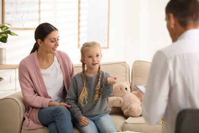 Photo of Child psychotherapist working with little girl and her mother in office