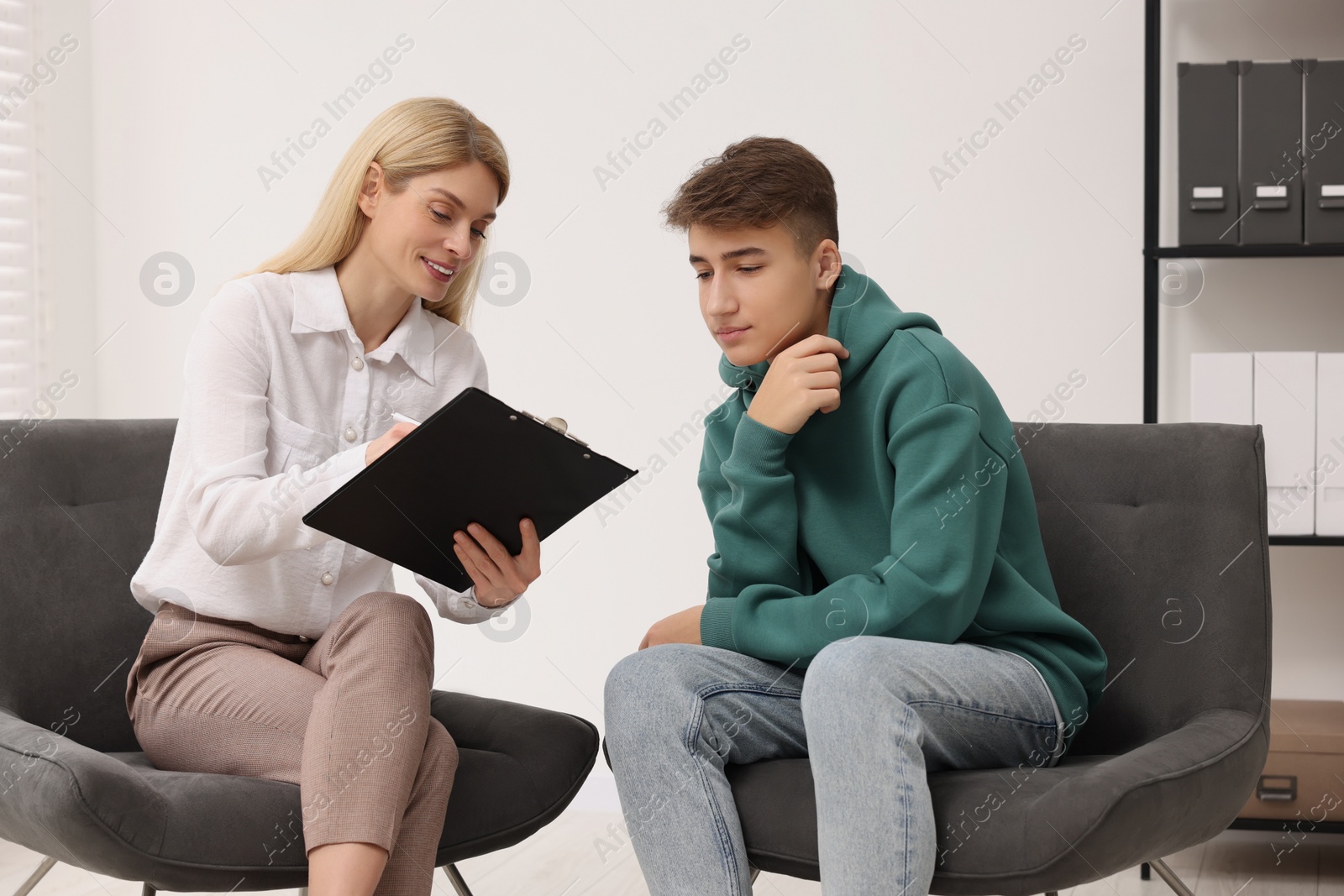 Photo of Psychologist working with teenage boy in office