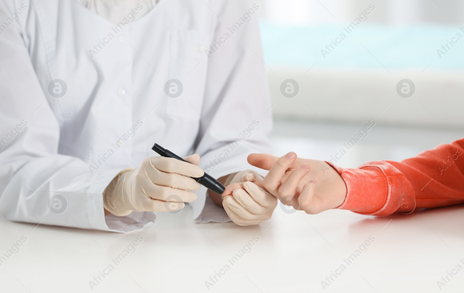 Photo of Doctor taking patient's blood sample with lancet pen in hospital, closeup. Diabetes control