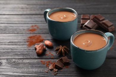 Photo of Yummy hot chocolate on black wooden table