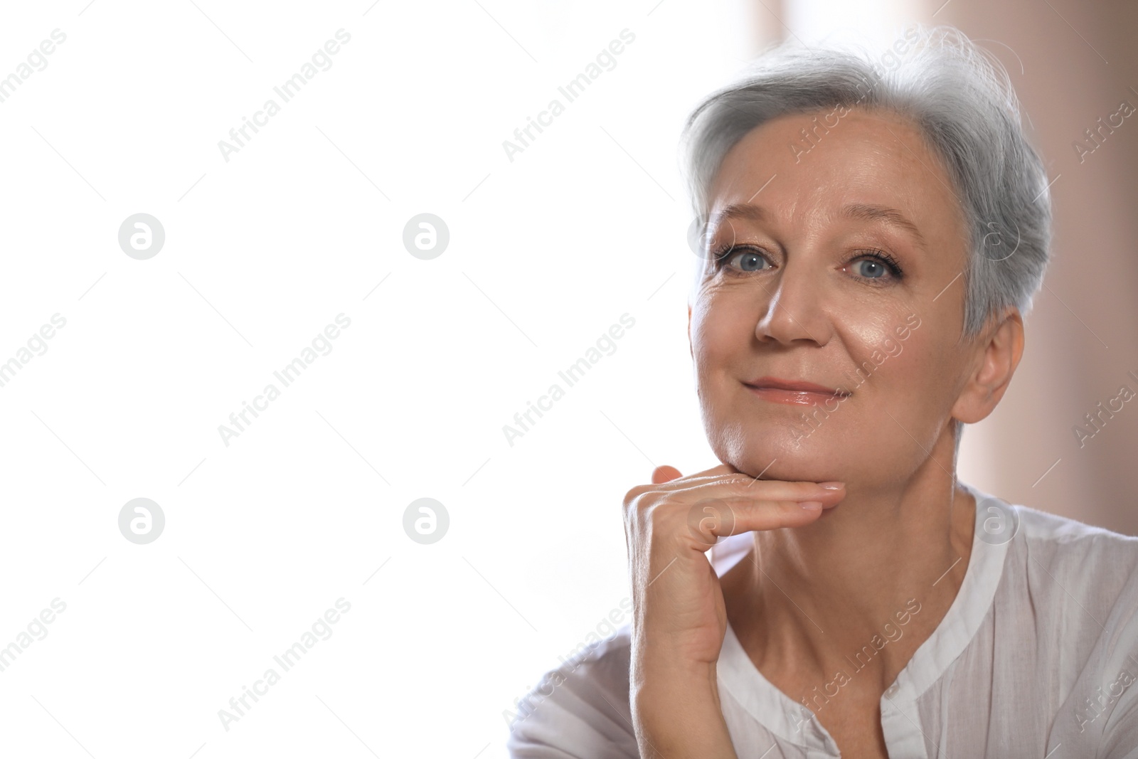 Photo of Happy mature woman near window indoors, space for text. Smart aging