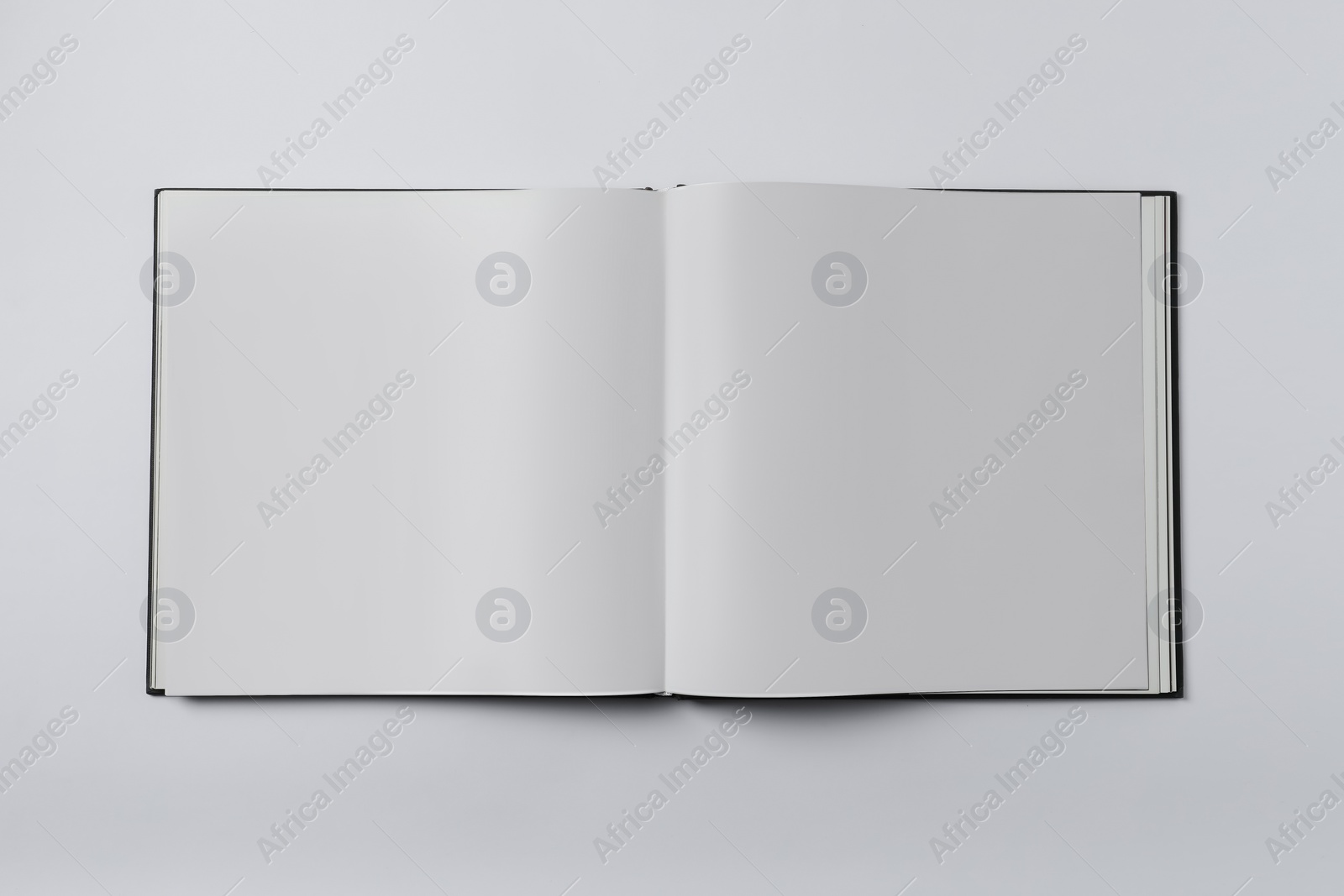 Photo of Open book on white background, top view