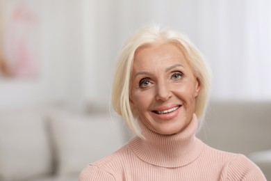 Photo of Portrait of happy mature woman indoors. Space for text