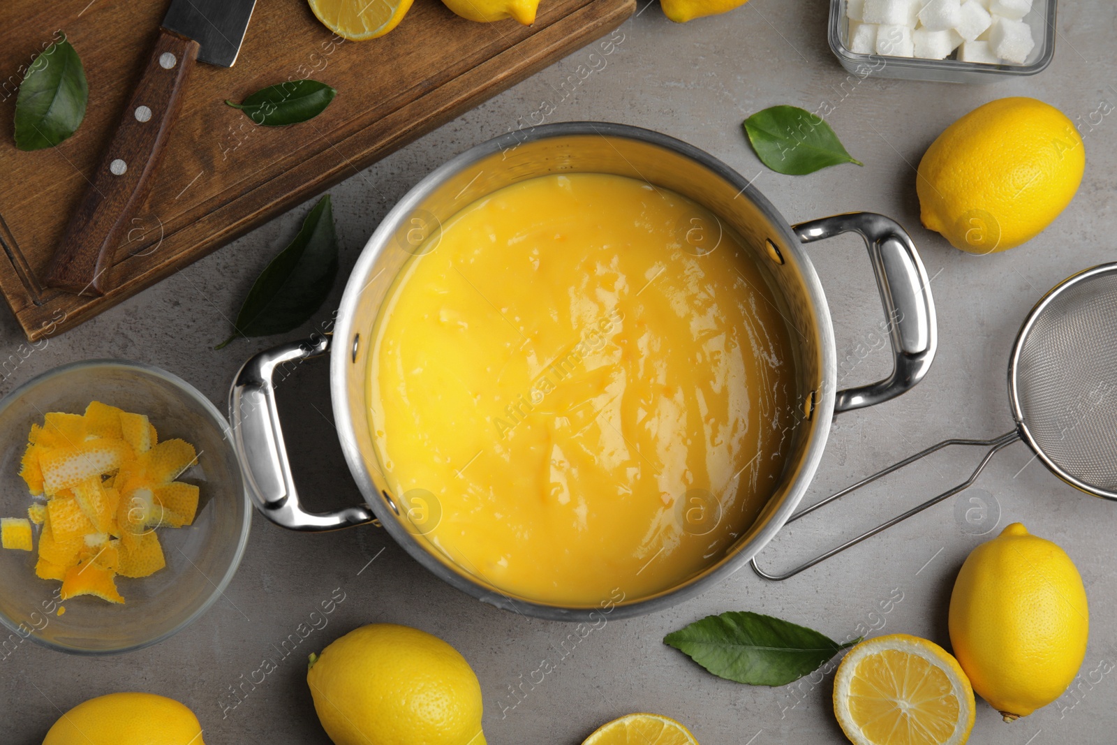 Photo of Delicious lemon curd and fresh fruits on grey table, flat lay