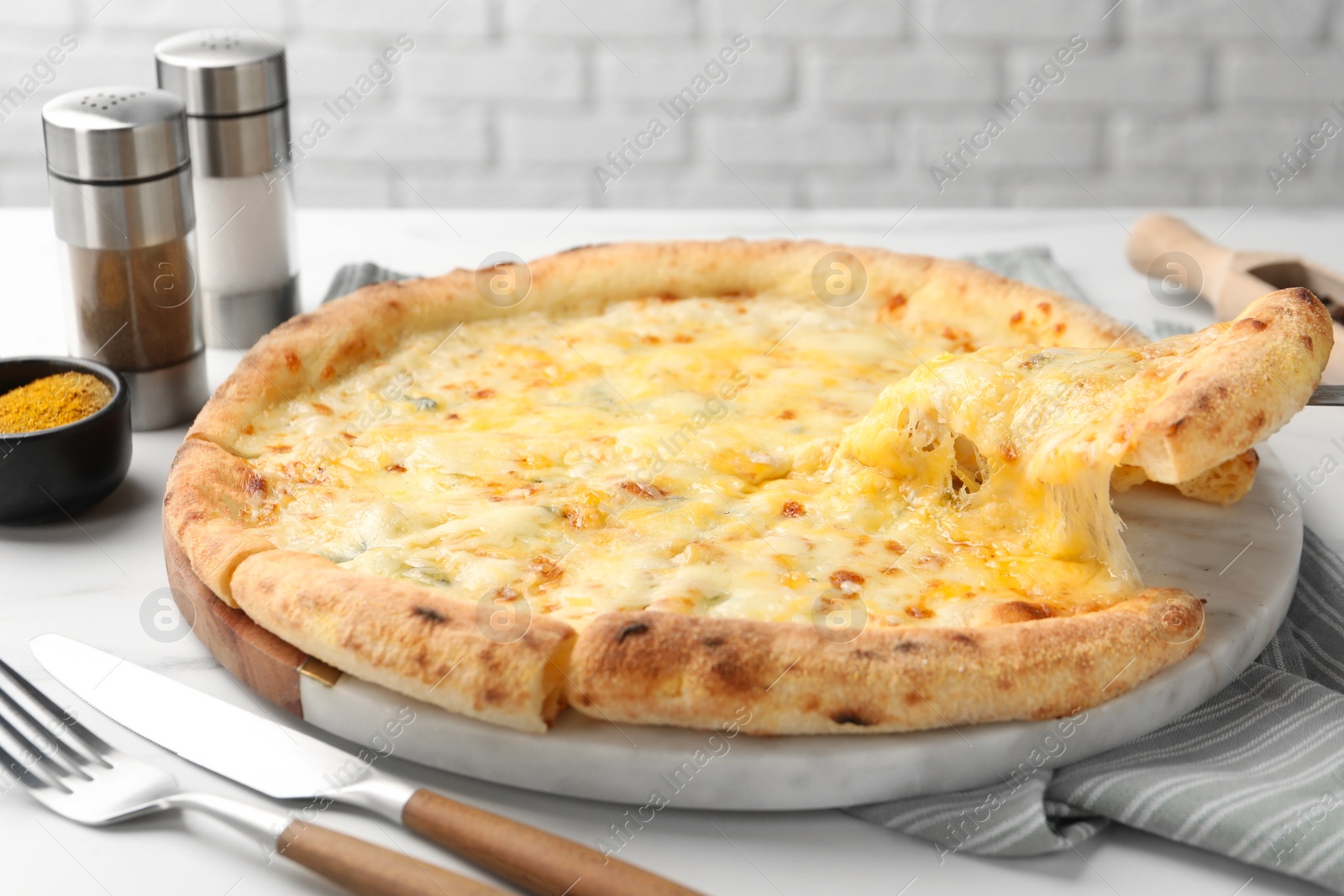 Photo of Taking piece of delicious cheese pizza at white table, closeup