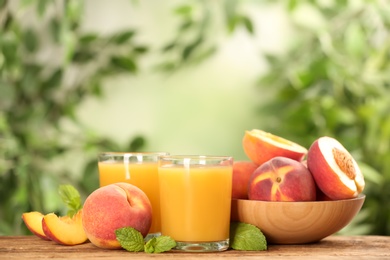 Natural peach juice and fresh fruits on wooden table