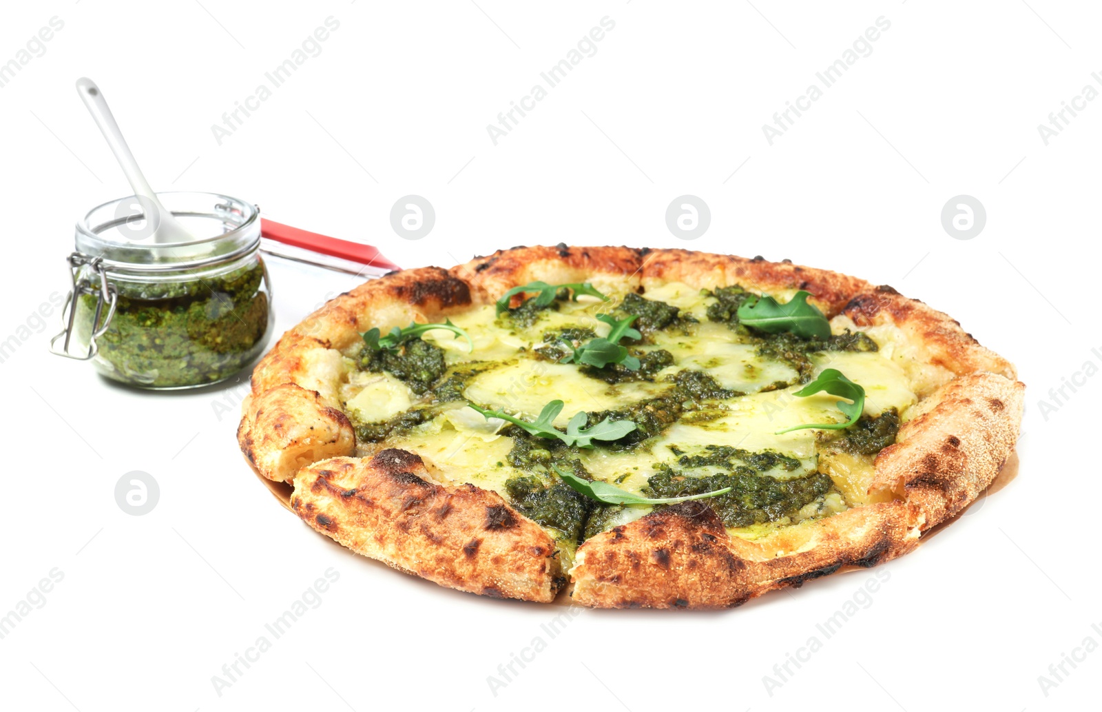 Photo of Delicious pizza with pesto, cheese and arugula near jar of sauce on white background