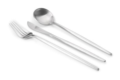 Photo of Shiny silver fork, knife and spoon isolated on white. Luxury cutlery set