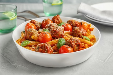 Delicious pasta with meatballs and tomato sauce on grey background